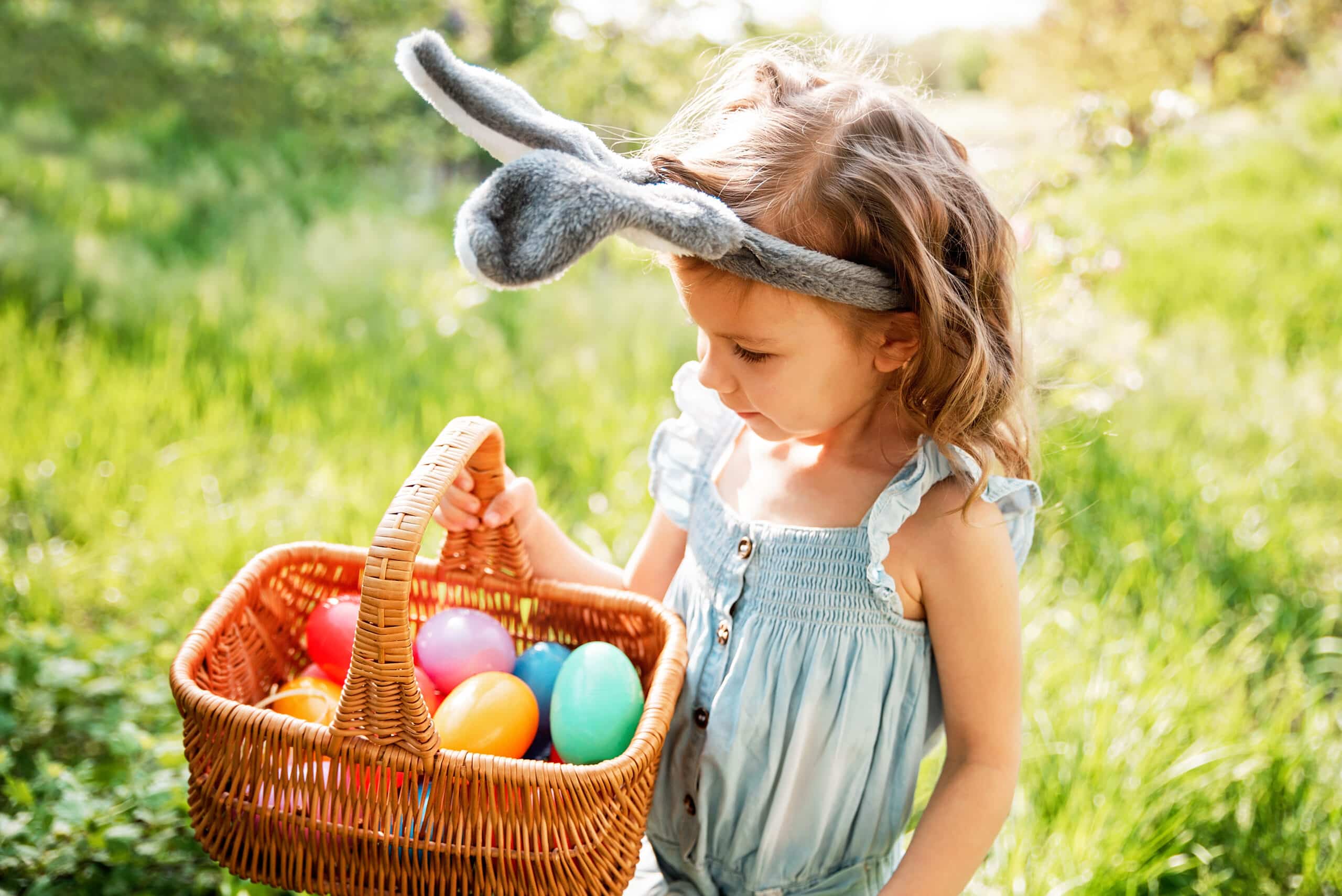 baby with basket full of colorful eggs. easter egg hunt.